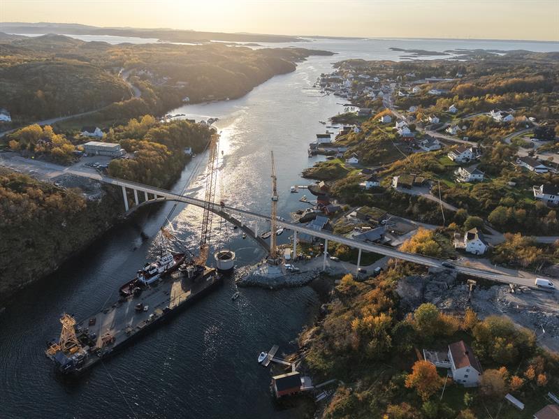 Dronebilde av at kranen senker senkekassen på plass i sundet.