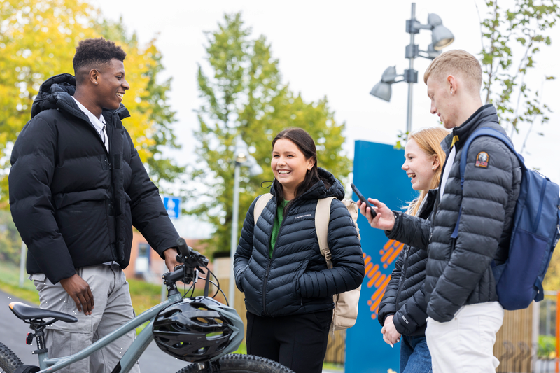 Fire elever står i ring og smiler til hverandre utenfor Tiller videregående skole. Fotograf: Ronny M Danielsen