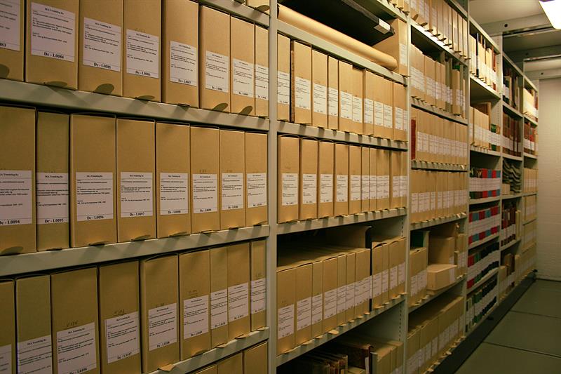 Hyller med arkivmateriale i brune bokser