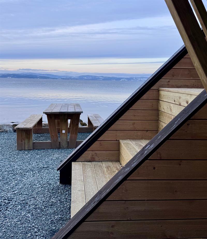 Det er trapp på utsiden av hytta som kan bli brukt som benk og utsiktspunkt. Arkitekt: Rojo Arkitekter AS. Foto: Tove Helland Pedersen/Trøndelag fylkeskommune.
