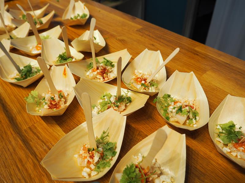 Råmarinert kamskjell i spicy tomatmajones. Fersk fra havet – servert i en liten trebåt. Foto: Ida Valsø.