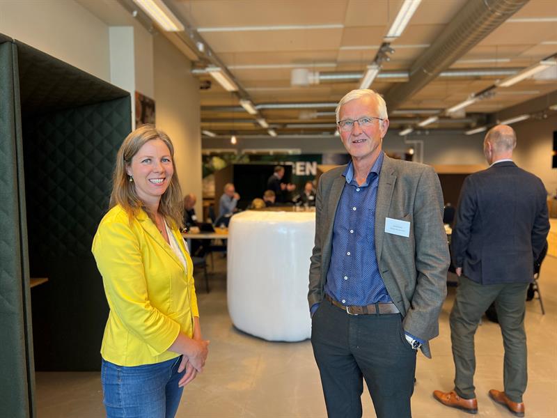 Lillian Strand, leder Grønt industriløft Trøndelag, sammen med seniorrådgiver Jacob B. Almlid i Steinkjer Næringsselskap smiler til kamera. I bakgrunn står andre deltakere. Foto: Ida Valsø