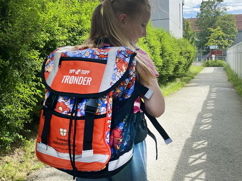 Jente med skolesekk. Bilde